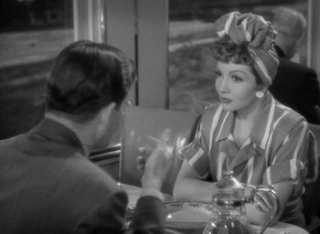 Movie still from “The Palm Beach Story” (1942), directed by Preston Sturges – A woman sitting at a table with a man; Medium shot, Over the shoulder angle