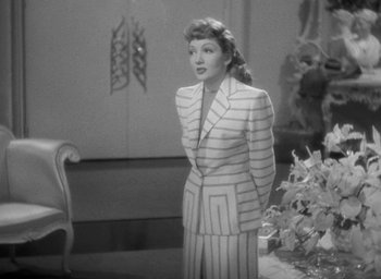 Movie still from “The Palm Beach Story” (1942), directed by Preston Sturges – A black and white photo of a woman in a suit; Medium shot, High angle