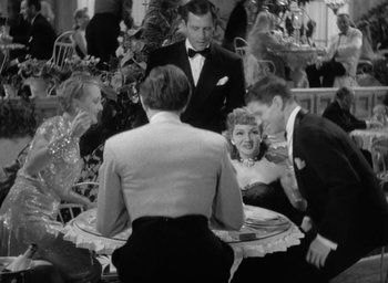 Movie still from “The Palm Beach Story” (1942), directed by Preston Sturges – A group of people sitting around a table at an event; Medium shot, High angle