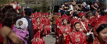 Movie still from “The Parallax View” (1974), directed by Alan J. Pakula – A group of women in red dresses walking down a street; Wide shot, High angle