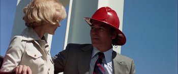 Movie still from “The Parallax View” (1974), directed by Alan J. Pakula – A man in a suit and a red hat talking to a woman; Close Up shot, Low angle