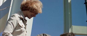 Movie still from “The Parallax View” (1974), directed by Alan J. Pakula – A woman standing next to another woman on a hill; Medium shot, Low angle
