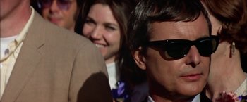 Movie still from “The Parallax View” (1974), directed by Alan J. Pakula – A man and a woman are smiling for the camera; Close Up shot, Low angle