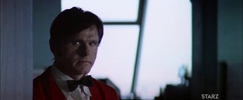Movie still from “The Parallax View” (1974), directed by Alan J. Pakula – A man wearing a red jacket and a bow tie; Close Up shot, Low angle