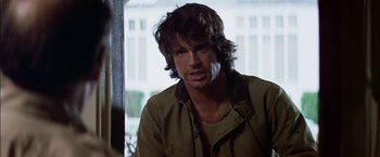 Movie still from “The Parallax View” (1974), directed by Alan J. Pakula – A person sitting in a room near a window; Close Up shot, Over the shoulder angle