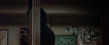Movie still from “The Parallax View” (1974), directed by Alan J. Pakula – A person standing in front of a window in a room; Close Up shot, Over the shoulder angle