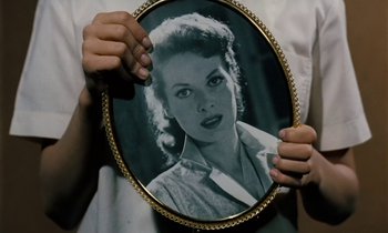 Movie still from “The Parent Trap” (1961), directed by David Swift – A person holding a picture of a woman in a frame; Extreme Close Up shot, Overhead angle