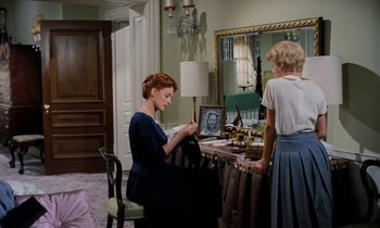 Movie still from “The Parent Trap” (1961), directed by David Swift – Two women are sitting at a table in front of a mirror; Medium shot, High angle