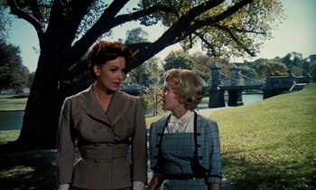 Movie still from “The Parent Trap” (1961), directed by David Swift – Two women standing next to each other under a tree; Medium shot, Over the shoulder angle
