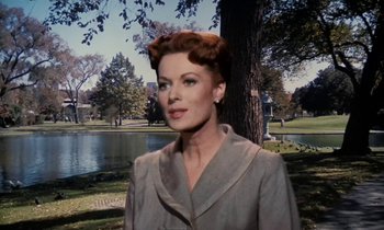 Movie still from “The Parent Trap” (1961), directed by David Swift – A woman in a gray coat standing in front of a lake; Close Up shot, Low angle