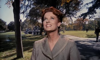 Movie still from “The Parent Trap” (1961), directed by David Swift – A woman in a gray coat standing in a park; Close Up shot, Low angle