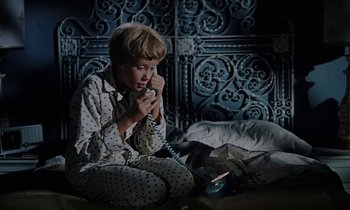Movie still from “The Parent Trap” (1961), directed by David Swift – A young boy sitting on the floor talking on a phone; Medium shot, High angle