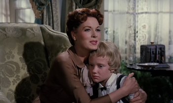 Movie still from “The Parent Trap” (1961), directed by David Swift – A woman and a boy are sitting in a living room; Medium shot, Low angle