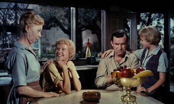 Movie still from “The Parent Trap” (1961), directed by David Swift – A group of people sitting around a table; Medium shot, Over the shoulder angle