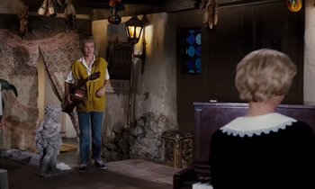 Movie still from “The Parent Trap” (1961), directed by David Swift – A man holding a guitar while standing next to a woman; Wide shot, Over the shoulder angle
