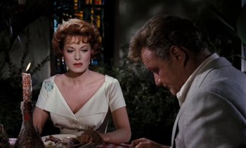Movie still from “The Parent Trap” (1961), directed by David Swift – An older man and woman sitting at a dinner table; Medium shot, Over the shoulder angle