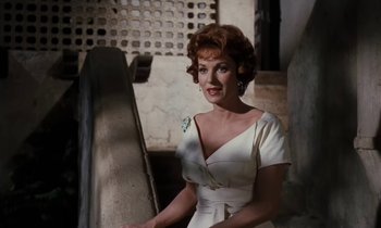 Movie still from “The Parent Trap” (1961), directed by David Swift – A woman in a white dress standing on some stairs; Medium shot, Low angle