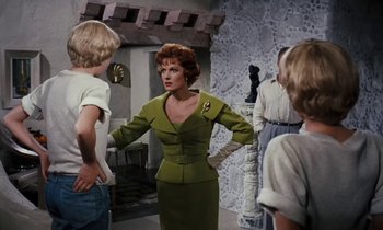 Movie still from “The Parent Trap” (1961), directed by David Swift – A group of people standing around in a room; Medium shot, Over the shoulder angle