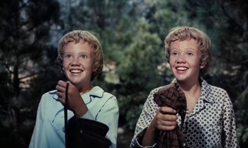 Movie still from “The Parent Trap” (1961), directed by David Swift – Two young boys smiling for the camera in front of trees; Close Up shot, High angle