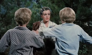 Movie still from “The Parent Trap” (1961), directed by David Swift – A woman with a curlers in her hair is looking at two other women; Medium shot, Over the shoulder angle