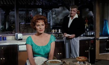 Movie still from “The Parent Trap” (1961), directed by David Swift – An older man and a woman in a kitchen; Medium shot, Over the shoulder angle