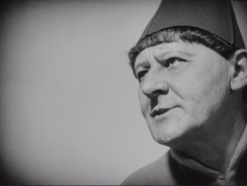 Movie still from “The Passion of Joan of Arc” (1928), directed by Carl Theodor Dreyer – An older man wearing a hat looking to his left; Close Up shot, Low angle