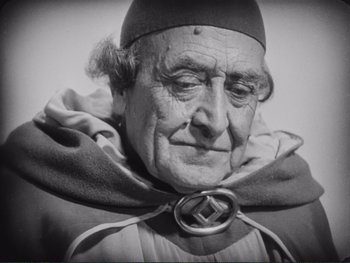 An old man wearing a hat and a cape