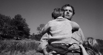 Movie still from “The Pawnbroker” (1964), directed by Sidney Lumet – A black and white photo of a man holding a young boy; Medium shot, Low angle