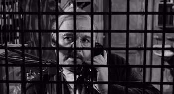 Movie still from “The Pawnbroker” (1964), directed by Sidney Lumet – An older man talking on a phone behind bars; Close Up shot, Low angle