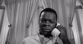 Movie still from “The Pawnbroker” (1964), directed by Sidney Lumet – A black and white photo of a man talking on a phone; Close Up shot, Low angle