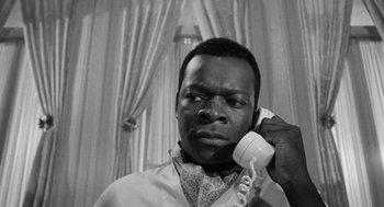 Movie still from “The Pawnbroker” (1964), directed by Sidney Lumet – A black and white photo of a man holding a phone to his ear; Close Up shot, Low angle