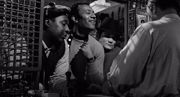 Movie still from “The Pawnbroker” (1964), directed by Sidney Lumet – A group of men standing next to each other in a room; Medium shot, Low angle