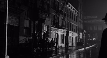Movie still from “The Pawnbroker” (1964), directed by Sidney Lumet – A group of people sitting on the side of a building; Extreme Wide shot, Low angle