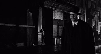 Movie still from “The Pawnbroker” (1964), directed by Sidney Lumet – A black and white photo of a man in a suit and tie; Medium shot, Low angle