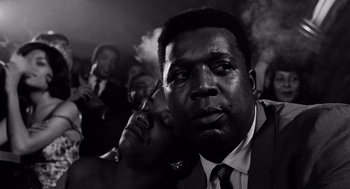 Movie still from “The Pawnbroker” (1964), directed by Sidney Lumet – A black and white photo of a man smoking a cigarette; Close Up shot, Low angle