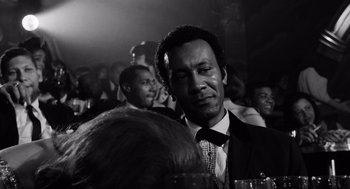 Movie still from “The Pawnbroker” (1964), directed by Sidney Lumet – A black and white photo of a man in a suit and tie; Close Up shot, Over the shoulder angle