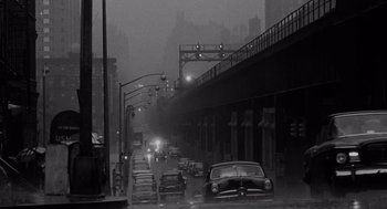 Movie still from “The Pawnbroker” (1964), directed by Sidney Lumet – A black - and - white photo of a city street in the rain; Extreme Wide shot, High angle