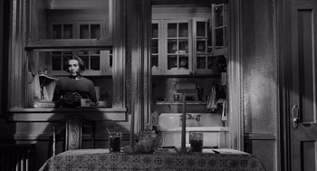 Movie still from “The Pawnbroker” (1964), directed by Sidney Lumet – A black and white photo of a woman in a kitchen; Medium shot, High angle