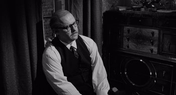 Movie still from “The Pawnbroker” (1964), directed by Sidney Lumet – An old man sitting in front of an old fashioned radio; Medium shot, Over the shoulder angle