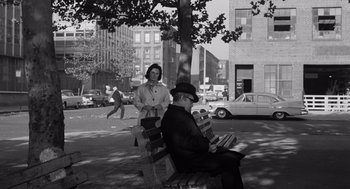 Movie still from “The Pawnbroker” (1964), directed by Sidney Lumet – An older man sitting on top of a bench next to an older woman; Wide shot, Low angle