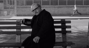 Movie still from “The Pawnbroker” (1964), directed by Sidney Lumet – An older man sitting on top of a wooden park bench; Medium shot, Low angle