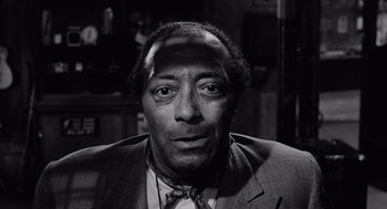 Movie still from “The Pawnbroker” (1964), directed by Sidney Lumet – A black and white photo of a man in a suit and tie; Close Up shot, Low angle