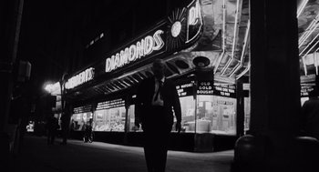 Movie still from “The Pawnbroker” (1964), directed by Sidney Lumet – A black and white photo of a man walking down the street; Wide shot, Low angle