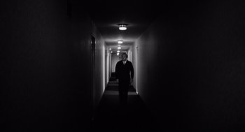 Movie still from “The Pawnbroker” (1964), directed by Sidney Lumet – A man walking down a long hallway in a dark room; Wide shot, Low angle