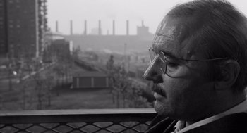Movie still from “The Pawnbroker” (1964), directed by Sidney Lumet – A black and white photo of a man looking out of a window; Close Up shot, Over the shoulder angle