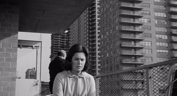 Movie still from “The Pawnbroker” (1964), directed by Sidney Lumet – A woman sitting in front of a tall building; Medium shot, Low angle