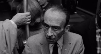 Movie still from “The Pawnbroker” (1964), directed by Sidney Lumet – An older man in a suit and tie on a bus; Close Up shot, High angle