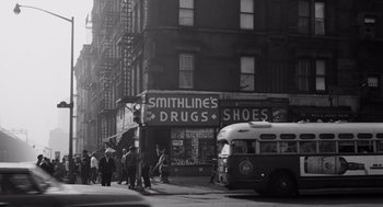 Movie still from “The Pawnbroker” (1964), directed by Sidney Lumet – A black - and - white photo of people walking down a street; Extreme Wide shot, High angle