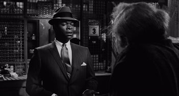 Movie still from “The Pawnbroker” (1964), directed by Sidney Lumet – A black and white photo of a man talking to a woman; Medium shot, Over the shoulder angle