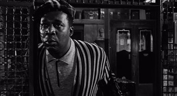 Movie still from “The Pawnbroker” (1964), directed by Sidney Lumet – A black and white photo of a man smoking a cigarette; Close Up shot, Low angle